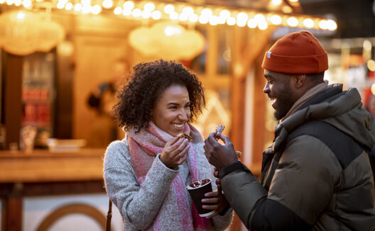 Two people drinking cocoa at a Christmas Market